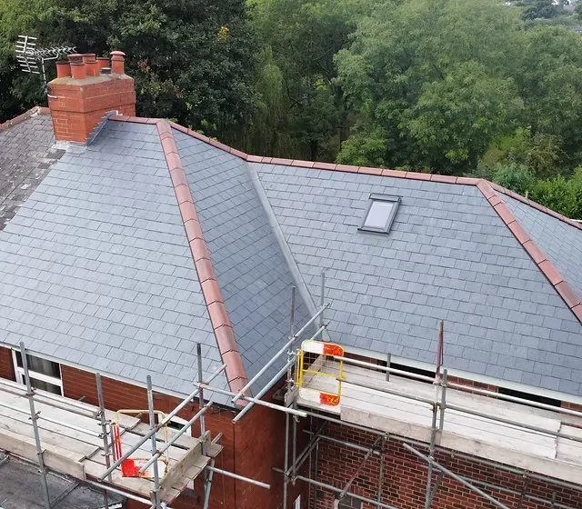 Hipped slate roof with red ridge tiles