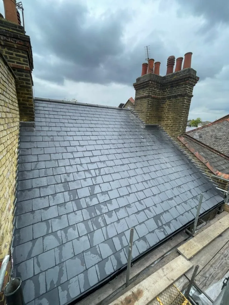 Roof re-slated between two brick chimneys