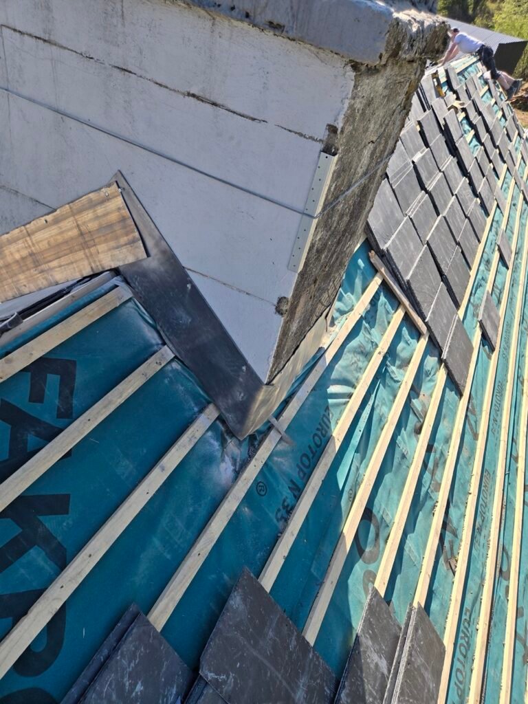 Lead step flashing formed at a wall abutment during a re-roof
