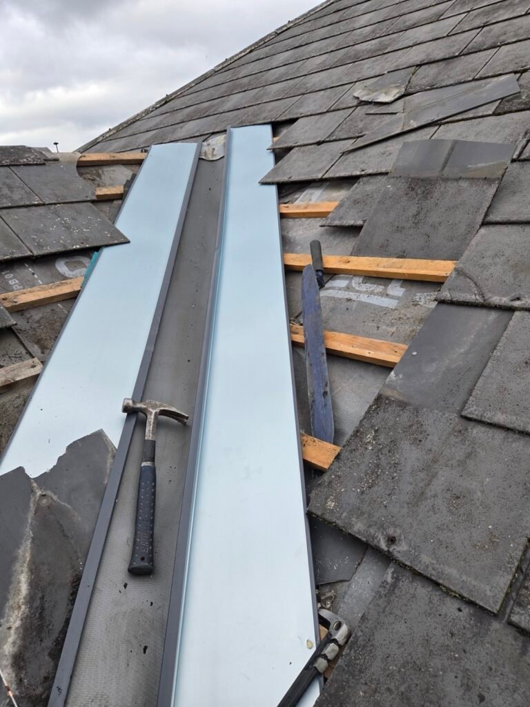 Preformed metal valley troughs being installed during a slate re-roof