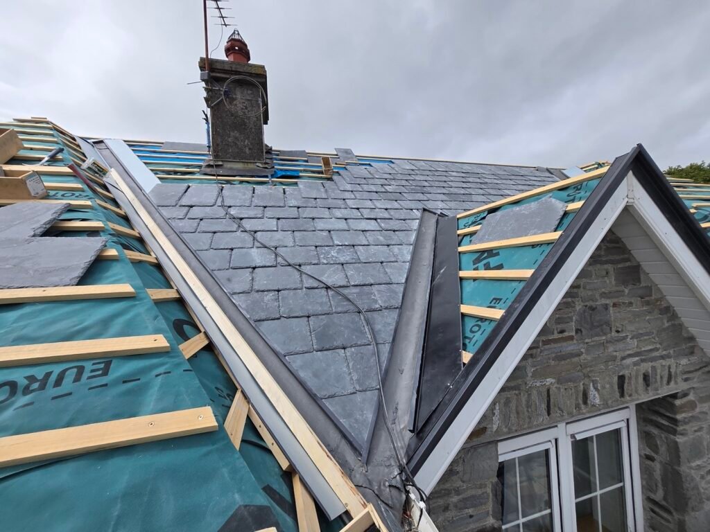 Valley and hip junction being formed on a slate roof