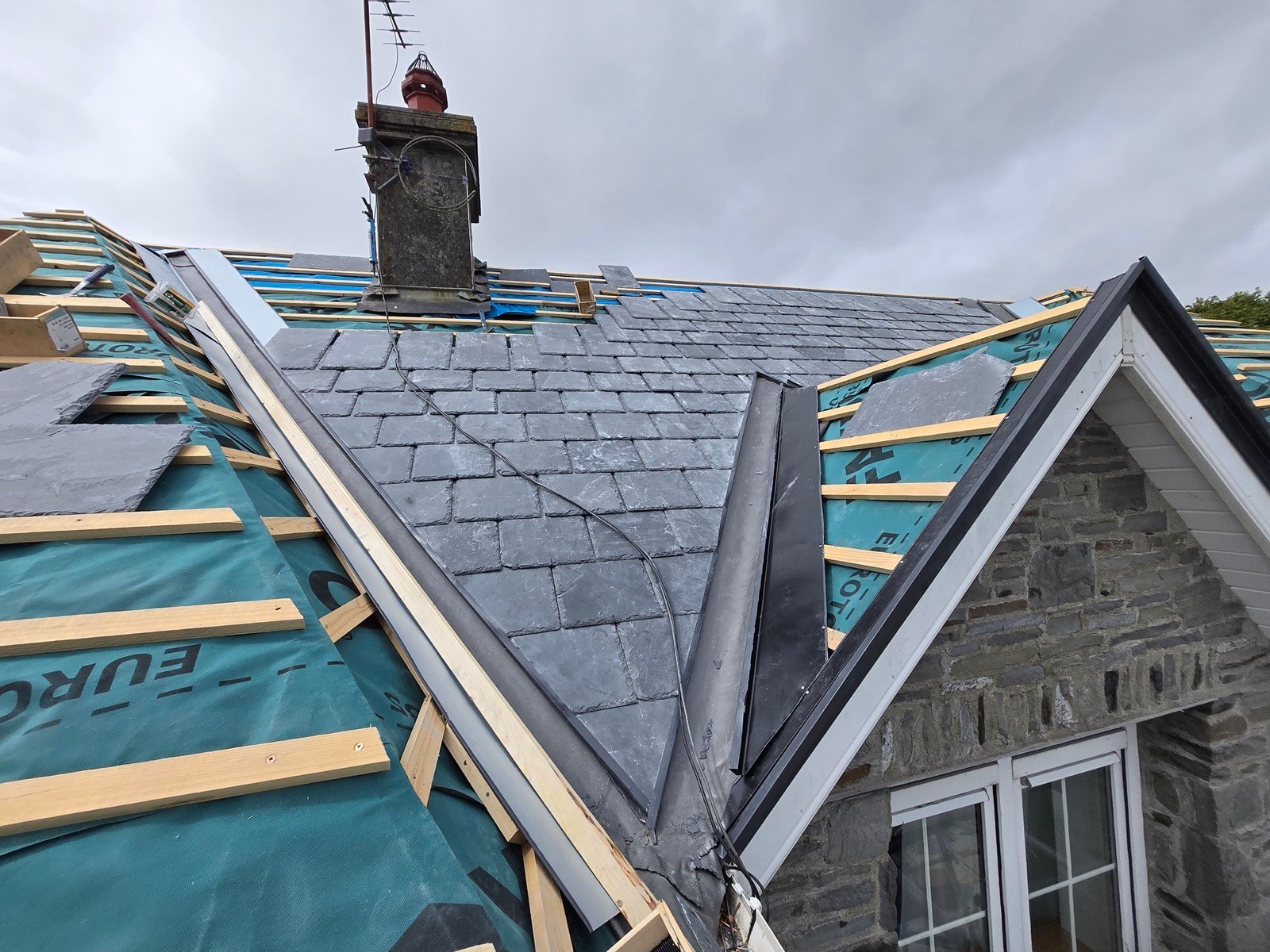Valley and hip junction being formed on a slate roof