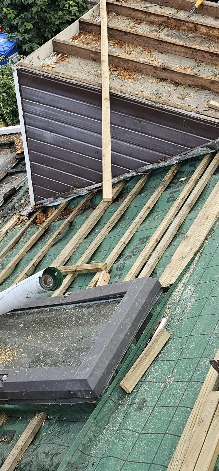 Roof stripped beside a dormer, new membrane and battens fitted around a roof window