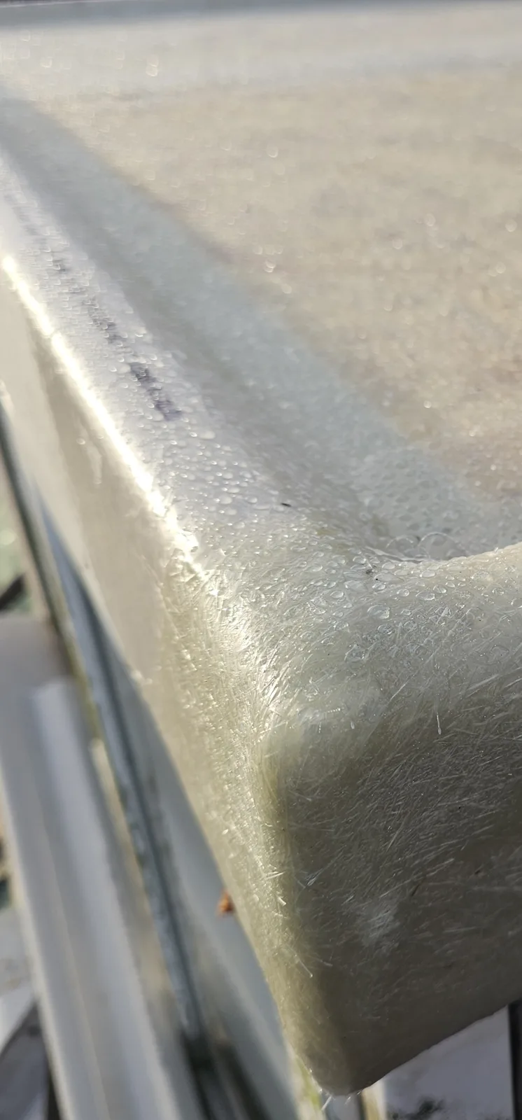 Corner of a GRP fibreglass flat roof edge trim, freshly laminated